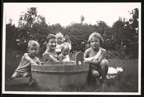 Fotografie Mutterglück, Mutter mit spielenden Kindern am Zuber im Garten