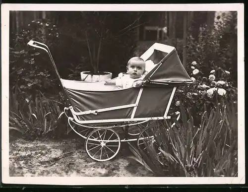 Fotografie niedliches Baby im Kinderwagen sitzend