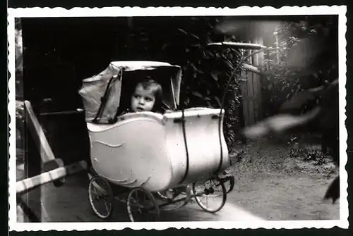 Fotografie kleines Mädchen hat sich im Kinderwagen versteckt