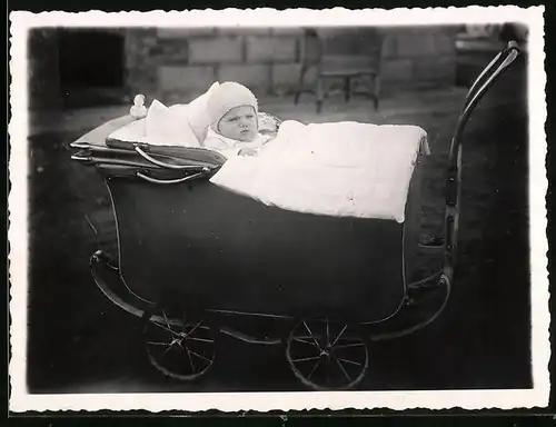 Fotografie Baby warm eingepackt im Kinderwagen liegend