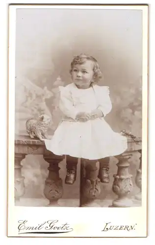 Fotografie Emil Goetz, Luzern, Hirschmattstrasse 8, Kleines Mädchen im weissen Kleid auf einer Mauer sitzend