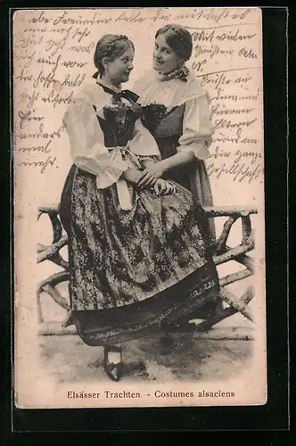 AK Zwei hübsche junge Frauen in Elsässer Tracht auf einem Zaun sitzend