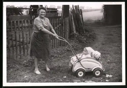 Fotografie Grossmutter schiebt Baby im Kinderwagen