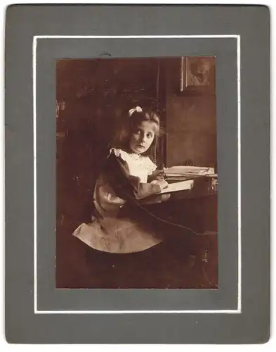 Fotografie unbekannter Fotograf und Ort, kleines Mädchen im Rüschenkleid mit einem Buch