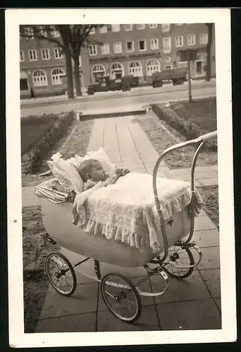 Fotografie niedliches Baby im Kinderwagen liegend