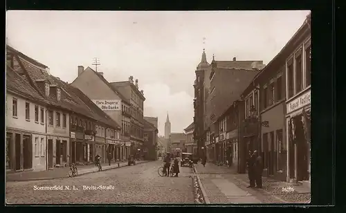 AK Sommerfeld /N.-L., Breite-Strasse mit Flora-Drogerie Otto Danke und Blick auf Kirche