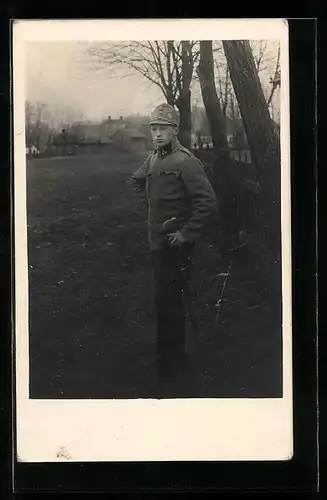 Foto-AK Junger österreichischer Soldat auf einem Feld vor einer Ortschaft
