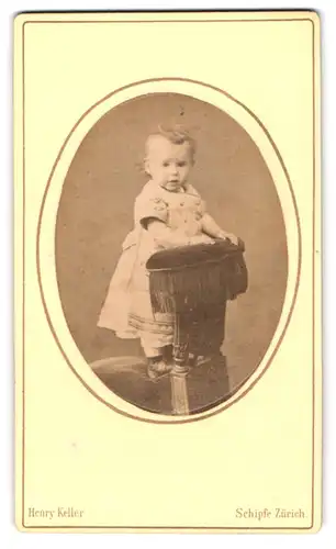 Fotografie Henry Keller, Zürich, Schüpfe Lachs 51, Portrait süsses blondes Mädchen steht auf einem Sessel