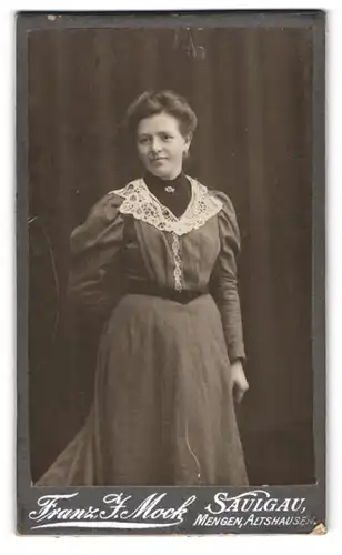 Fotografie Franz J. Mock, Saulgau, Portrait charmant lächelnde Dame im prachtvollen Kleid