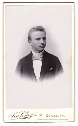 Fotografie Sev. Schoy, Colmar i. E., Stanislausstr. 4, Portrait blonder junger Mann mit Fliege im Jackett