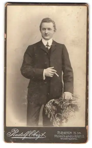 Fotografie Rudolf Obigt, Berlin, Reinickendorferstr. 2, Portrait junger charmanter Mann mit Zigarette in der Hand