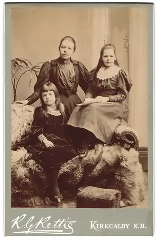Fotografie R. G. Rettie, Kirkcaldy /N.-B., Junge Dame im Kleid mit zwei Mädchen
