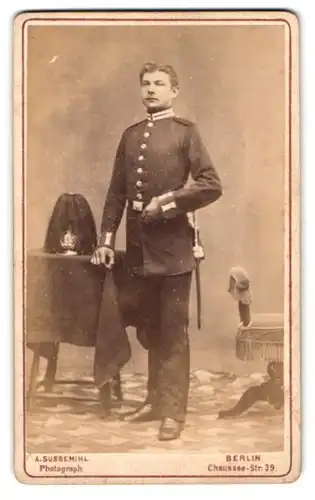 Fotografie A. Sussemihl, Berlin, junger Soldat in Garde Uniform mit Pickelhaube Rosshaarbusch auf dem Tisch