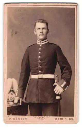 Fotografie P. Hörder, Berlin, Portrait Soldat in Garde Uniform mit Pickelhaube Rosshaarbusch, Bajonett