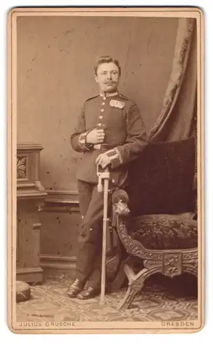 Fotografie Julius Grusche, Dresden, sächsischer Uffz. in Garde Uniform mit Ordenspange, Säbel mit Portepee