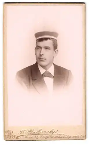 Fotografie Fr. Ratkowsky, Hamburg, Student Ferdinand im Anzug mit Fliege und Schirmmütze samt Couleur