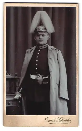 Fotografie Emil Schröter, Jüterbog, Soldat in Garde Uniform mit Picklehaube Rosshaarbusch, Uniformmantel