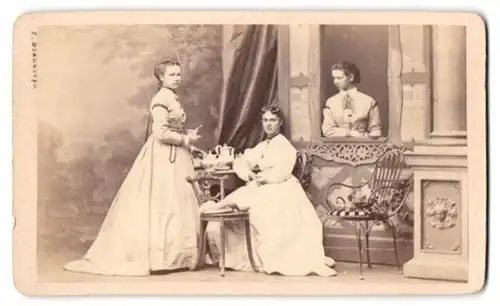 Fotografie F. Brandseph, Stuttgart, drei hübsche junge Damen beim Kaffekranz in einer Studiokulisse, 1867