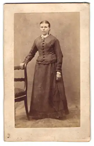 Fotografie unbekannter Fotograf und Ort, Portrait junge Frau im schlichten dunklen Kleid posiert im Atelier