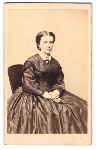 Fotografie C. Wolff, Neustrelitz, junge Dame im seidenen Kleid mit Brosche