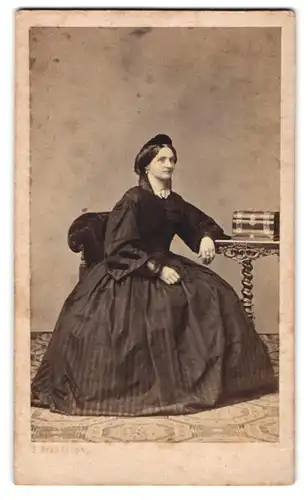 Fotografie F. Brandseph, Stuttgart, junge Frau im schwarzen gestreiften Kleid mit Kopfbedeckung