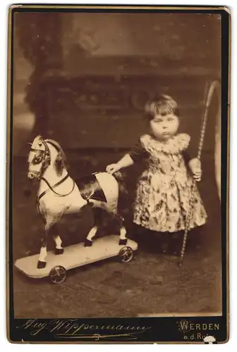 Fotografie Aug. Wippermann, Werden / Ruhr, kleines Mädchen im Kleid mit grossem Pferd auf Rollen