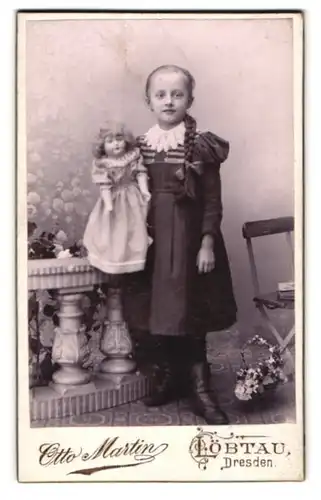 Fotografie Otto Martin, Löbtau, niedliches Mädchen im Kleid mit Zopf und Puppe im Arm