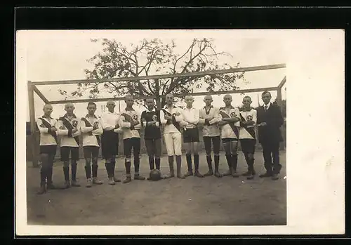 AK Mannschaftsbild eines Fussballteams vor einem Tor