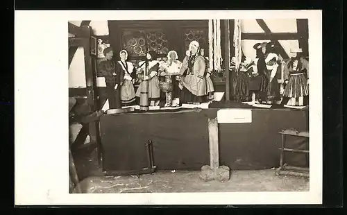 AK Puppen in Trachten auf einem Tisch