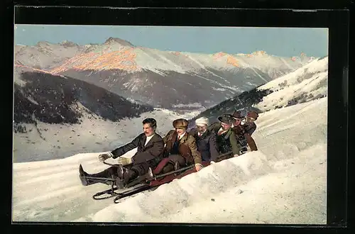 AK Gruppe auf Bob-Schlitten vor Bergkulisse