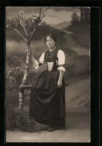 Foto-AK Junge Frau in Tracht vor Studiokulisse