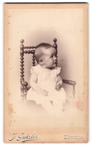 Fotografie J. Gutzler, Zürich, Bei der Sihlbrücke, Baby mit ängstlichem Blicck auf einem Stuhl