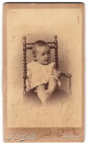 Fotografie J. Gutzler, Zürich, Bei der Sihlbrücke, Baby in verspielter Haltung auf einem Stuhl