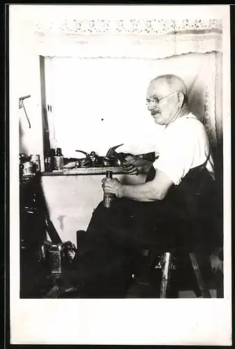 Fotografie Schuhmacher bei der Arbeit in seiner Werkstatt