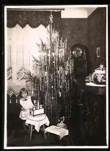 Fotografie Weihnachten, Mädchen mit Kinderküche vor dem Weihnachtsbaum