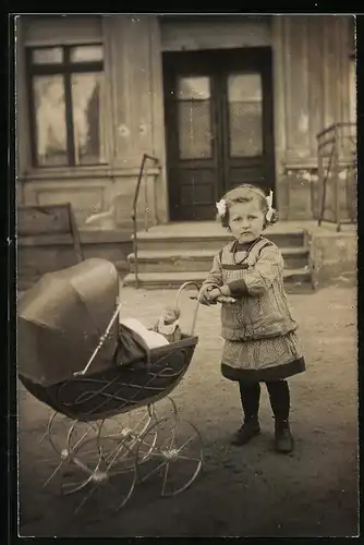 Fotografie niedliches Mädchen mit Puppe im Puppenwagen