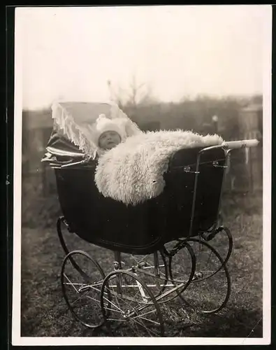 Fotografie Baby mit Felldecke im Kinderwagen liegend