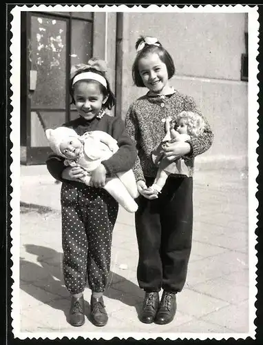 Fotografie Spielzeug, lachende Mädchen mit Puppe im Arm