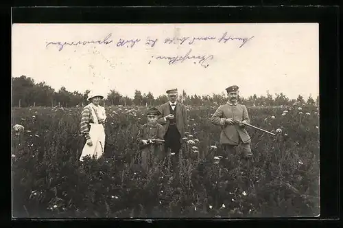 Foto-AK Jäger mit Gewehren und Frau auf einer Blumenwiese