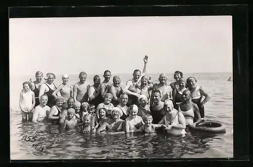 Foto-AK Vergnügte Gruppe mit Kindern im Wasser an der See, Bademode