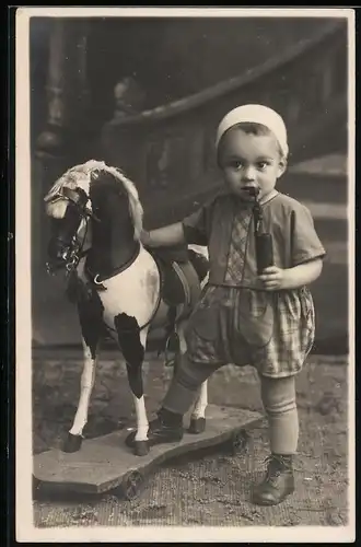 Fotografie Kleinkind nebst Spielzeug-Pferd