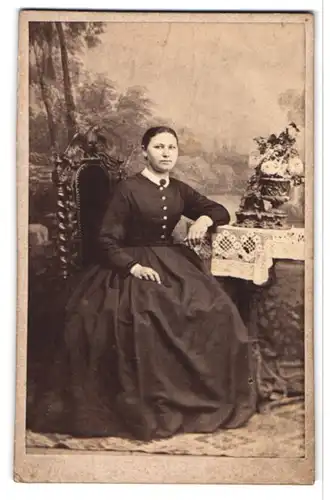 Fotografie W. Gräfer, Cottbus, junge Dame im schwarzen Kleid posiert sitzend am Tisch