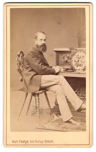 Fotografie Karl Feste, Erfurt, Herr Emil Petit im Anzug mit Vollbart posiert sitzend im Atelier, 1876