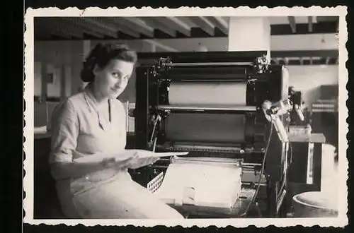Fotografie Druckerei, Fabrikarbeiterin nimmt Bögen einer Druckmaschine ab