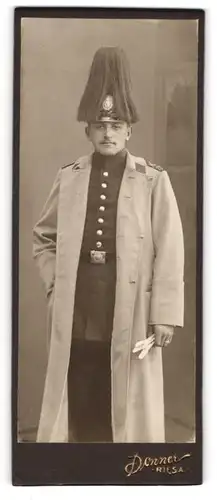 Fotografie Donner, Riesa, Portrait sächsischer Soldat in Uniform mit Mantel und Pickelhaube mit Rosshaarbusch