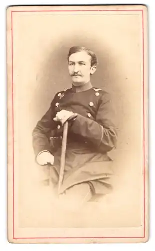 Fotografie Adolph Erkelenz, Aix-La-Chapelle, Portrait Offizier Erich von Rabe in Uniform sitzend mit Krücke, 1872