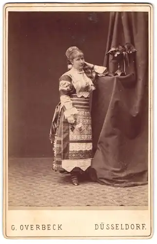 Fotografie G. Overbeck, Düsseldorf, Schauspielerin im Trachtenkleid posiert im Atelier