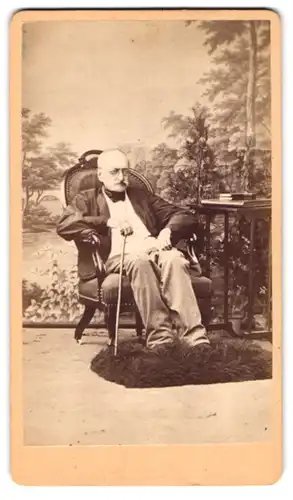 Fotografie Joh. Tschopp, Gleichenberg, Portrait Maximilian Graf d`Orsay im Anzug mit Stock, sitzend im Atelier