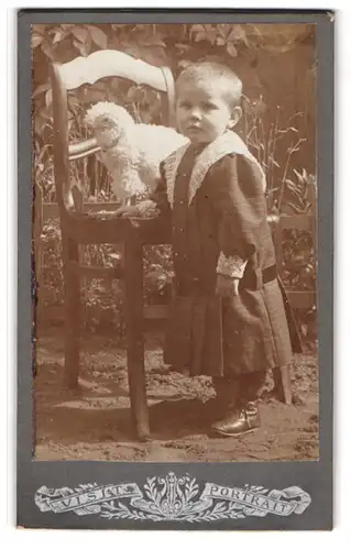 Fotografie unbekannter Fotograf und Ort, Kleines Kind im karierten Kleid mit einem Spieltier