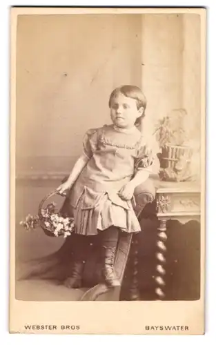Fotografie Webster Bros, Bayswater, 4, Porchester Road, Hübsch gekleidetes Kind mit Blumenkorb